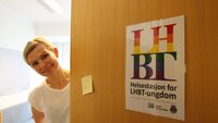 Biildet viser Ingun Wik som titter ut av en &aring;pen d&oslash;r p&aring; LBHT-helsestasjonen.