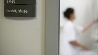 Antibiotikaresistens, hygiene, smittevern Bildet viser en dør inn til en sluse til et isolat og en sykepleier kan skimtes.