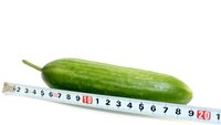 Størrelse Illustrasjonfoto av en agurk ved siden av målebånd