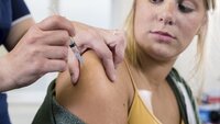 Bildet viser en ung jente som f&aring;r hpv-vaksine av en sykepleier.