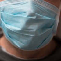  Bildet viser en mann med munnbind. 