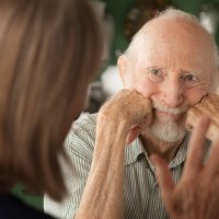 Bildet viser en eldre mann som studerer en kvinne som prater til ham.