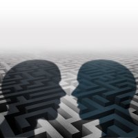 Bildet viser silhuetten av to mennesker som står ovenfor hverandre. I bakgrunnen kan man skimte en labyrint.