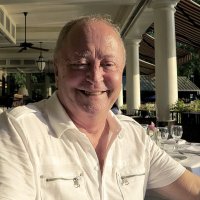 Bildet viser en smilende Jan Pedersen som koser seg på uterestaurant.