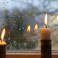 Bildet viser to stearinlys i et vindu