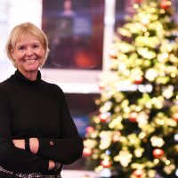 Bildet viser Anne Hafstad, redaktør i Sykepleien, smilende foran et tent juletre