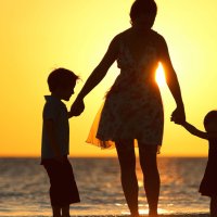 Familie i solnedgang på strand