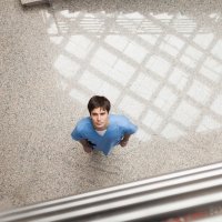 Bildet viser en sykepleier som titter opp mot kamera