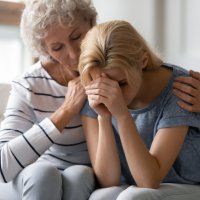 En ung jente får trøst av et familiemedlem