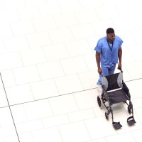 Bildet viser sykepleier som triller en tom rullestol