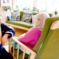  pleier i slåbrok sammen med eldre på et hjem