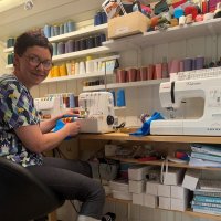 Bildet viser sykepleier Katrine Vinje Kleiven som syr Supermann-luer.