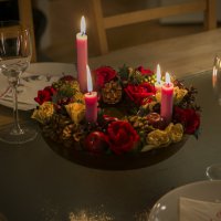 Bildet viser et middagsbord som er pyntet med julelys og blomster