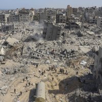 Bildet viser palestinere som går gjennom ødelagte områder etter en israelsk militæroperasjon mot Shifa-sykehuset på Gazastripen.