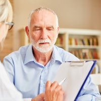 Sykepleier i samtale med pasient.